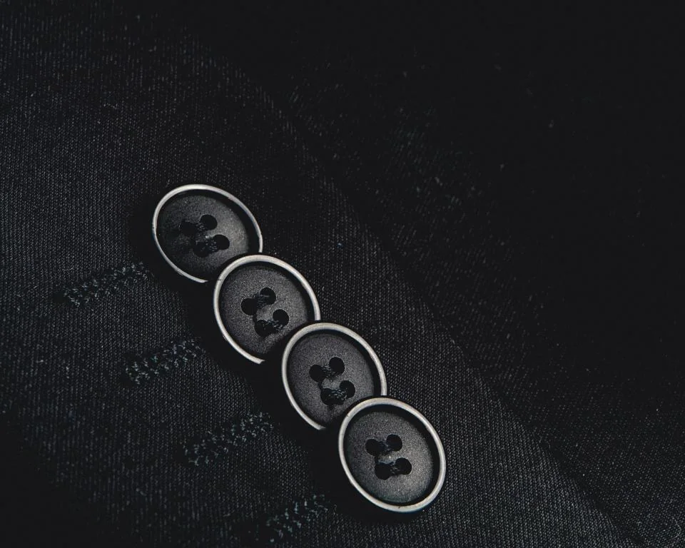 Detalle de botones en la manga de una chaqueta oscura