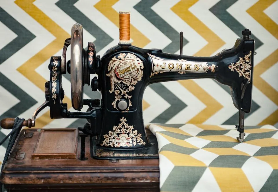 Máquina de coser antigua sobre tela de estampado geométrico