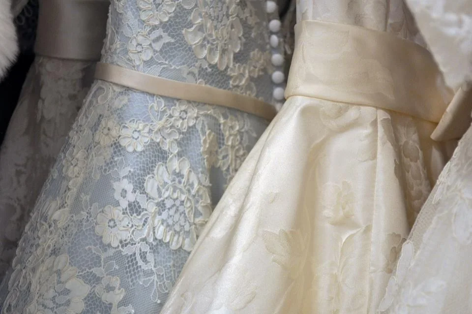 Vestidos de novia de encaje colgados en el taller